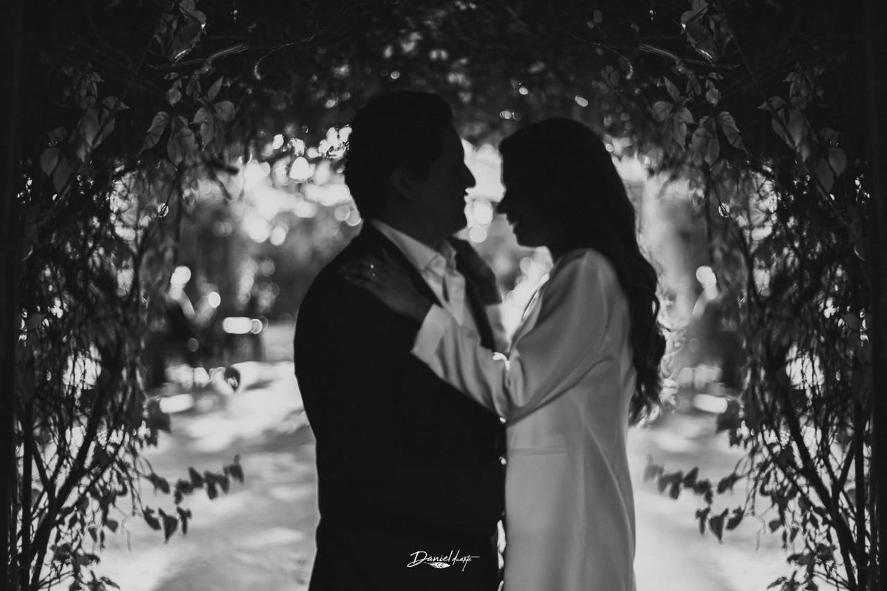 Silueta de la pareja en arco de flores